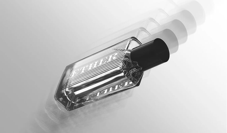 Aether: l'essenza immateriale della scia di un profumo racchiusa in un flacone rettangolare dalle linee morbide. La serigrafia si trasforma in un'incantevole esperienza cinetica: un semplice movimento innesca un effetto ottico che fa apparire e scomparire il logo. Design di Jules Dinand.